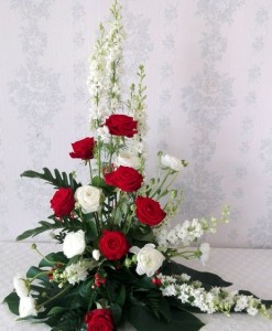 Begravningsdekoration med vita och röda blommor